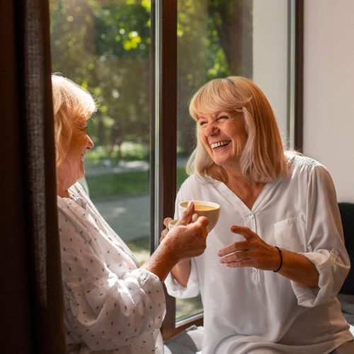 close-up-smiley-women-holding-cups